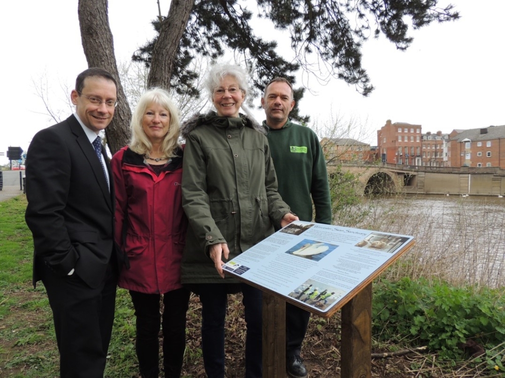 Volunteers unveiling a new information board on the riverside